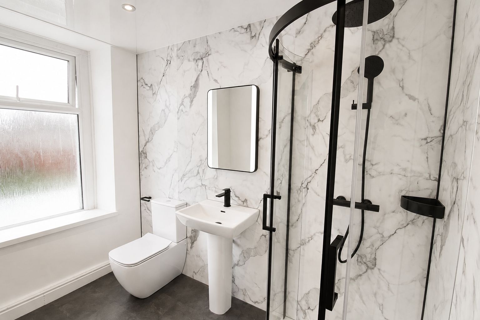 Home 18 Modern student bathroom with marble tiles, white toilet, sink, and black shower enclosure with frosted glass window at Lancaster student accommodation